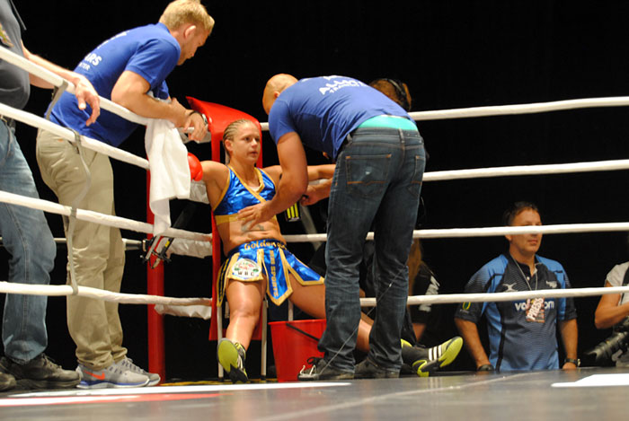 Den första rondpausen. Till vänster skymtar MMA-fightern Alexander Gustafsson. Notera hur Frida sitter som en hösäck – efter en rond.