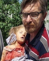 FÖRTVIVLAD FAR bär sin döda lilla dotter. Polina Sladkaya blev 6 år och är bara ett av många barn som Kiev och etablissemanget i väst har på sitt samvete.