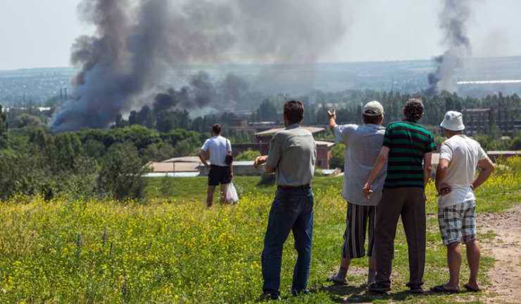 UPPRÖRDA SLAVJANSKBOR ser hjälplöst på när deras stad bombas av Kievs styrkor.
