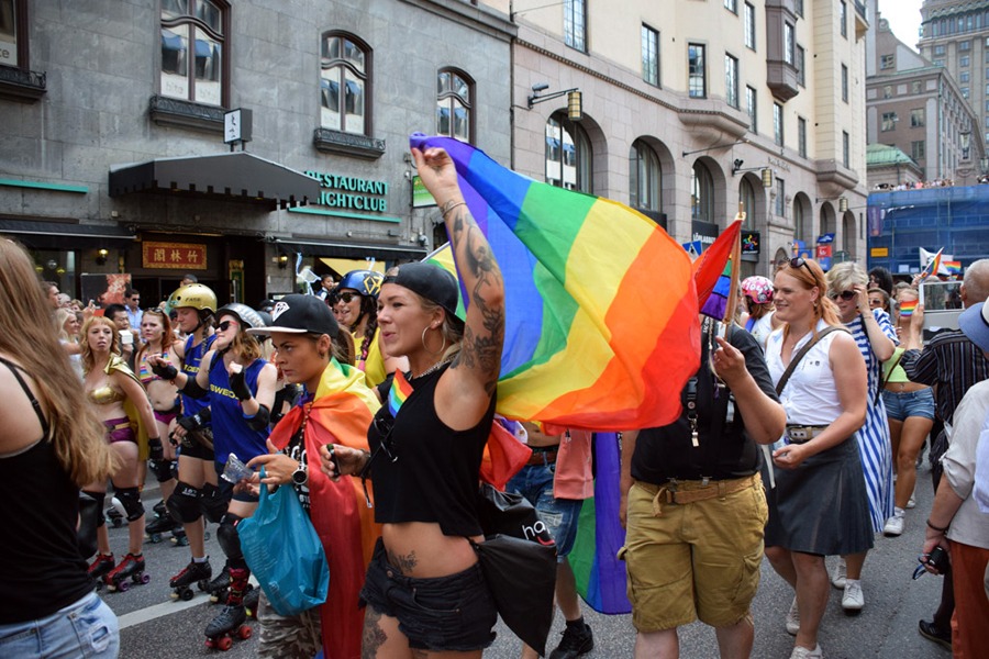 Ett lesbiskt par med regnbågsflaggor.