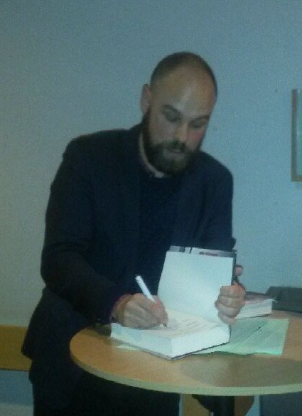 Daniel Suhonen signerar sin bok. Foto: Nya Tider