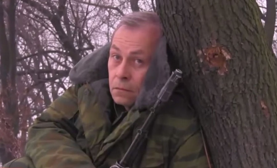 okänd separatistsoldat. Denne äldre man som tagit upp vapen för att försvara sin hembygd är en terrorist om man ska tro Kiev och en rysk elitsoldat om man tror västmedia. Här ses han försvara Putilovski-bron. Notera kulhålet i trädet i hans huvudhöjd.  Stillbild från LiveNews.