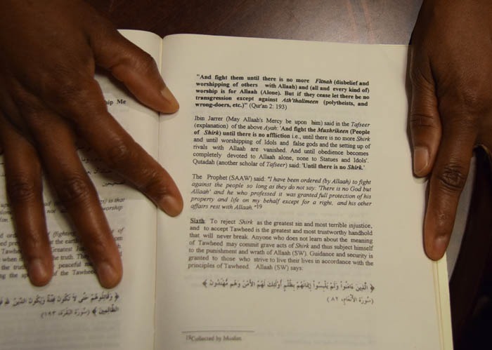 Mona visar boken som förklarar hur man ska tolka Koranen.