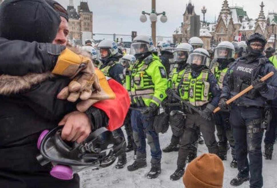 maskerad polis utan namnbrickor eller tjänstenummer använde batonger och pepparsprej för att bryta upp demonstrationen mot Kanadas federala regering. Stillbild: Privat